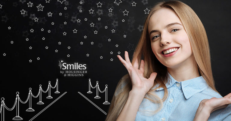 woman smiling in fron of simulated red carpet drawing